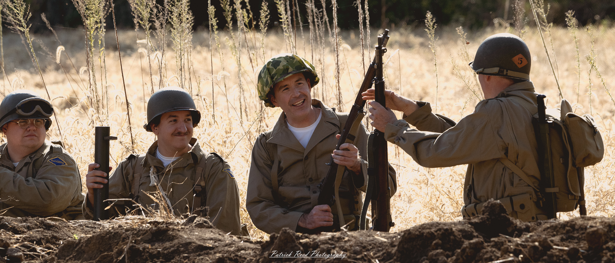 "Image of a group of four U.S. soldiers smiling together, showcasing camaraderie and friendship. Dressed in their military uniforms, they stand close together, embodying a sense of unity and brotherhood. The background features a scenic military setting, perhaps with tents or vehicles, capturing a moment of light-heartedness amidst the seriousness of their duty. The soldiers' smiles radiate warmth and a shared bond, reflecting their experiences together in the field."